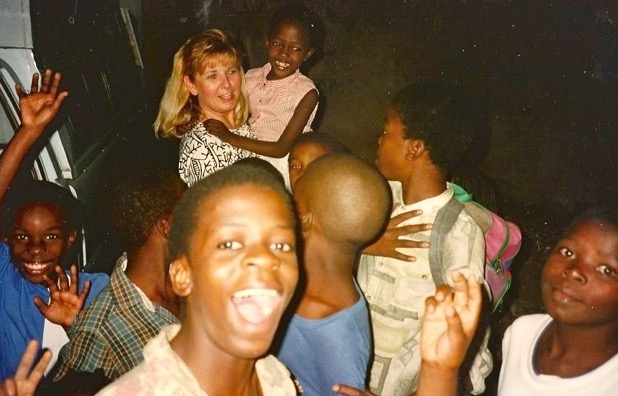 Smiling children gathered around the ministry team on a mission trip in Africa