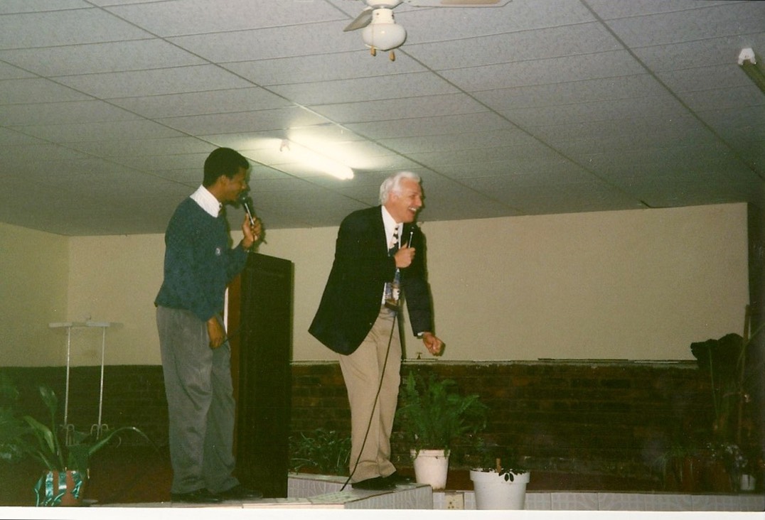 Rev. Steven A. Bach preaching beside an interpreter at a church in Africa